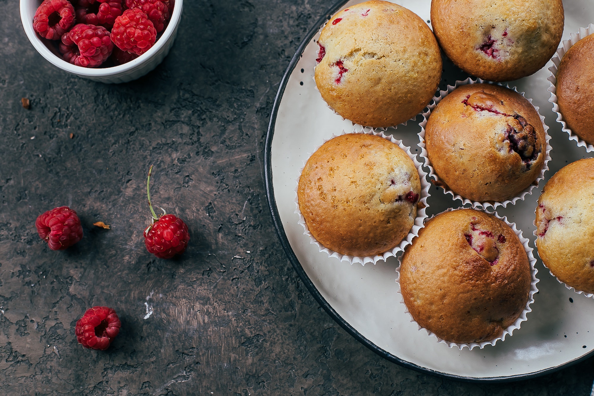 Raspberry muffins on plate light concrete background. Top view, flat lay